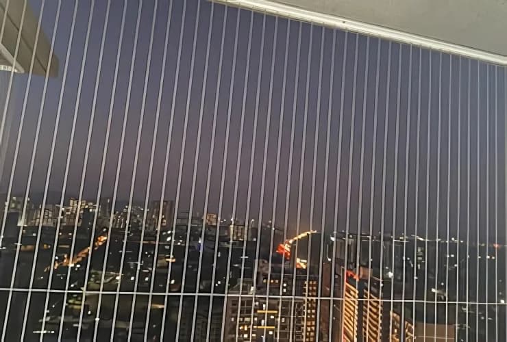 Dusk view through a fine-wire balcony grill